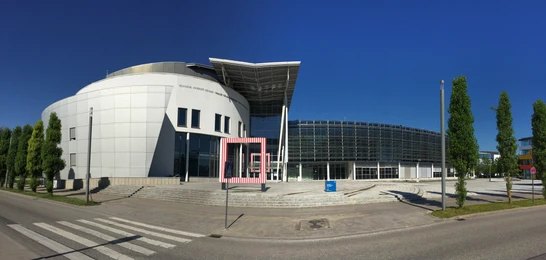 Modern building of the Technical University of Munich (TUM) in Germany, featuring sleek architecture and a clear blue sky in the background.